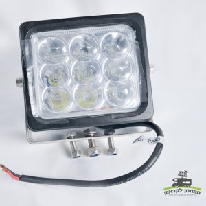 פרוג'קטור סולארי מרובע, 9 לדים בהספק 120W, מתח הפעלה 12V – מותאם למערכות פוטו-וולטאיות ולתשתיות אנרגיה מתחדשת. מותקן על זרוע מתכת עם שלושה ברגים ומחובר לכבל חשמל שחור להזנת מתח מתחנת כוח ניידת או מערכת סולארית עצמאית. אידיאלי לתאורה בפרויקטי אנרגיה ירוקה. לוגו בעברית בפינה הימנית התחתונה.