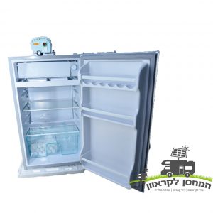 מקרר לבן פתוח+מקפיה 92 ליטר 12V עם מדפים ריקים ותא הקפאה קומפקטי, מיועד לקירור יעיל מחוץ לרשת באמצעות אנרגיה סולארית וטכנולוגיה פוטו-וולטאית; אידיאלי עבור תשתית אנרגיה מתחדשת, ייצור חשמל עם תחנות כוח ניידות או ציוד לקמפינג. טקסט ולוגו בעברית הכוללים סמל פאנל סולארי בצד ימין למטה מדגישים פתרונות אנרגיה בת קיימא.