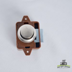 תקריב של מנעול דחיפה חום וכסוף (כפר נעליים בלחיצה) עם ידית עגולה, המותקנת על משטח לבן, מיועד לשימוש במערכות אנרגיה סולארית ותשתיות טכנולוגיה פוטו-וולטאית כגון קרוואנים או יחידות אגירת אנרגיה מתחדשת. בפינה הימנית התחתונה מופיע לוגו המקושר לייצור אנרגיה סולארית ופתרונות משולבים של אנרגיה מתחדשת.